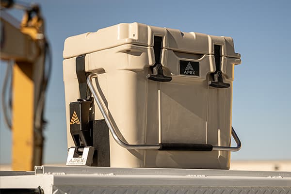 Close up image of a khaki Apex A20 cooler securely mounted to a work truck